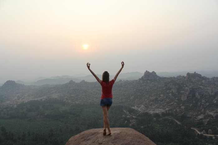 Arms lifted wide to the sunrise on a granite outcrop