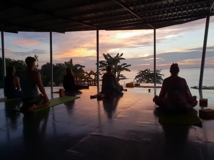 Silhouettes practising in an open shala at sunset