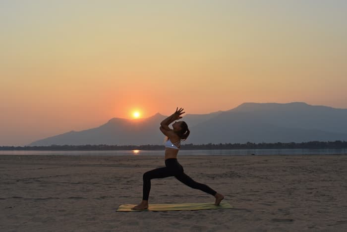 Warrior pose silhouetted against the setting sun