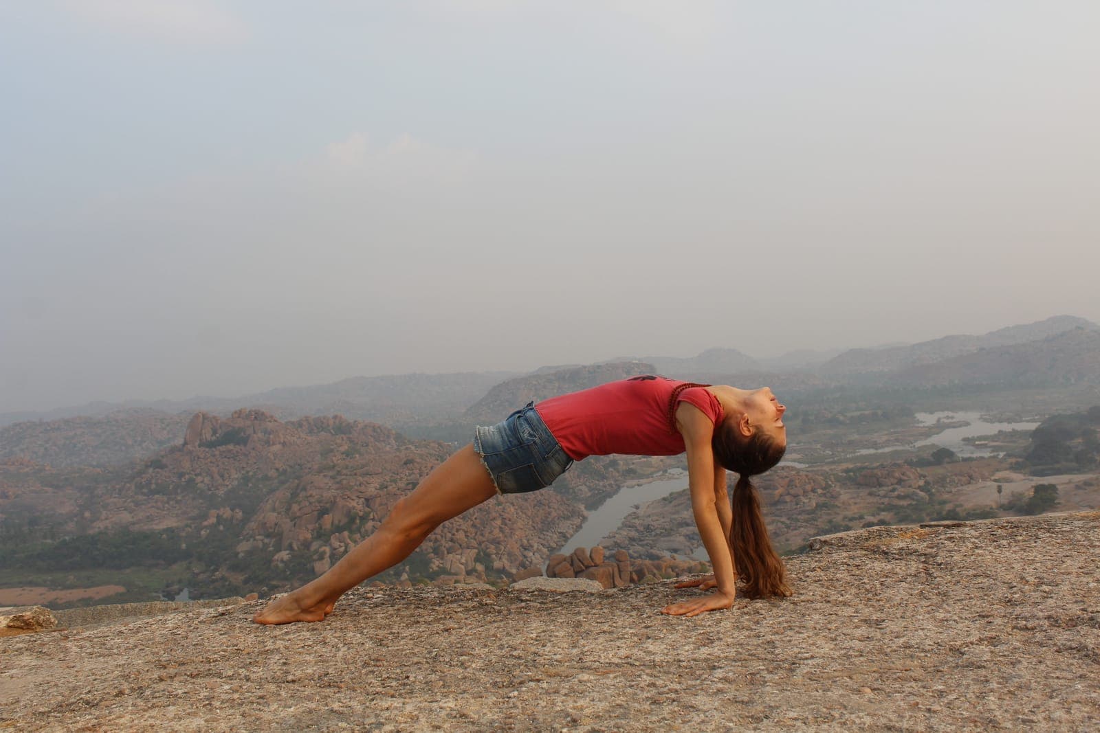 Downward-facing dog on a warm granite slab at sunrise